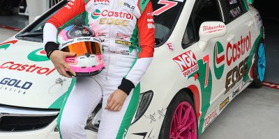 leona chin malaysia motorsport athlete in racing suit next to her honda civic racing car color castrol racing team with ngk cap